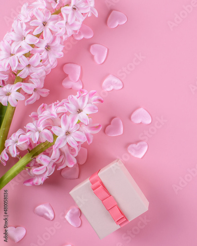 Gift or present box, beautiful pink hyacinth flowers and pink hearts on pink table top view. Flat lay composition for Valentines day, birthday, mother day or wedding, monochrome © Anna Fedorova