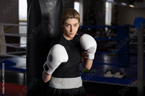 Woman boxer stays in defend a position in the boxing ring