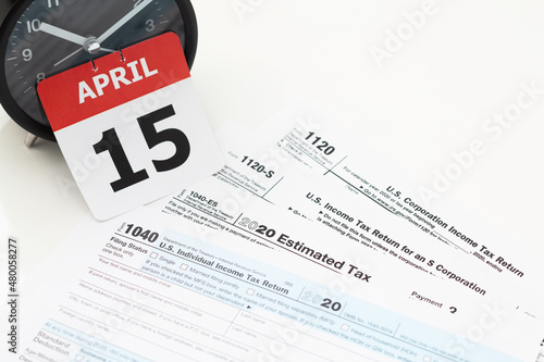 April 15 Tax Day deadline concept - calendar page, tax returns, and clock