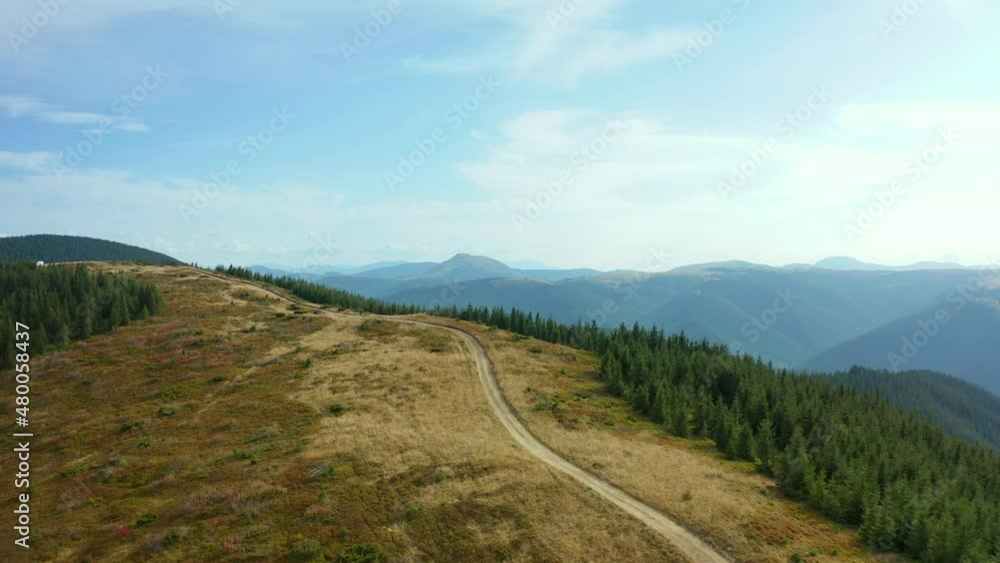 Aerial mountain path scene with stunning rocky pikes background against sky Aerial mountain path scene with stunning rocky pikes background against sky