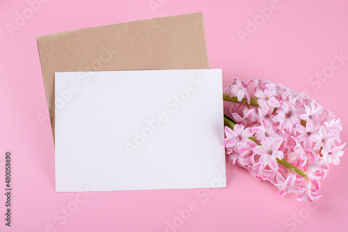 Blank wedding invitation stationery card mockup with envelope on pink background with hyacinth flowers © Anna Fedorova