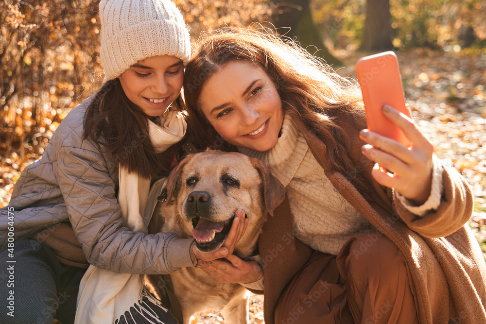 Mother, her teen daughter and their labrador dog making self portrait together