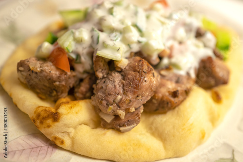 Pork Gyro Greek dish in a pita with cucumber, tomato, and yogurt sauce