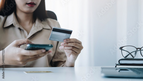 Online payment,woman's hands holding smartphone and using credit card for online shopping. Cyber Monday Concept