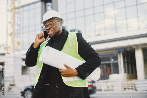 Black architect with project talk by phone