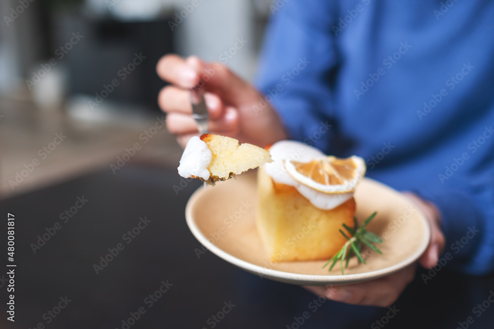 Closeup of a woman holding and eating a piece of lemon pound cake Closeup of a woman holding and eating a piece of lemon pound cake