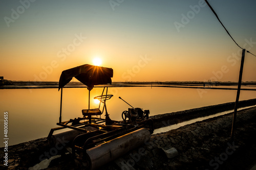 Salt farm with salt roller car in salt field at Khok Kham, Samut Sakhon province, Thailand photo