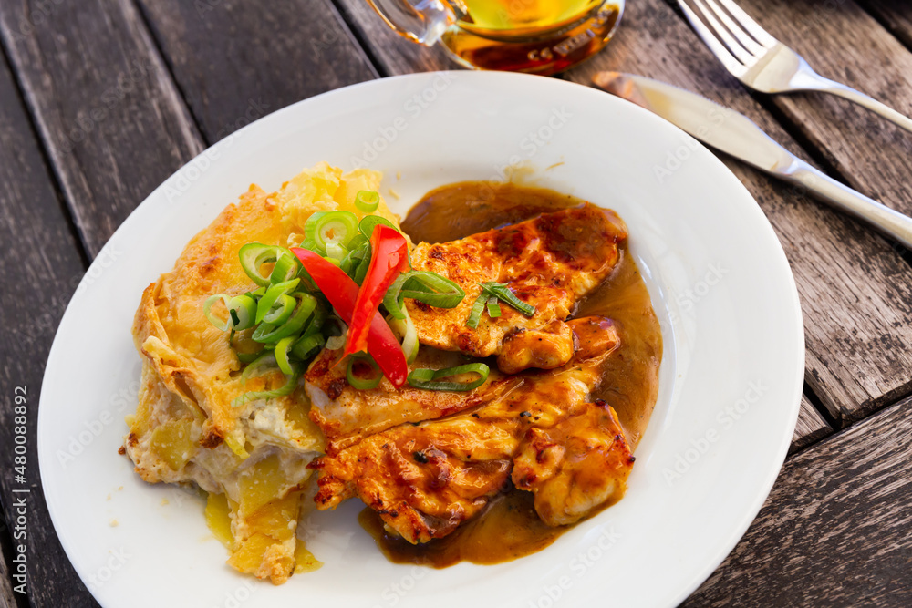 Czech dish - chicken with baked potato served with sauce and greens