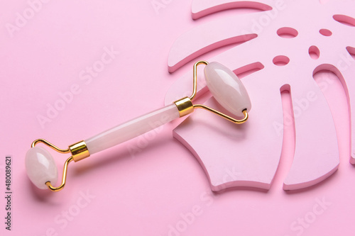 Face massage roller on color background