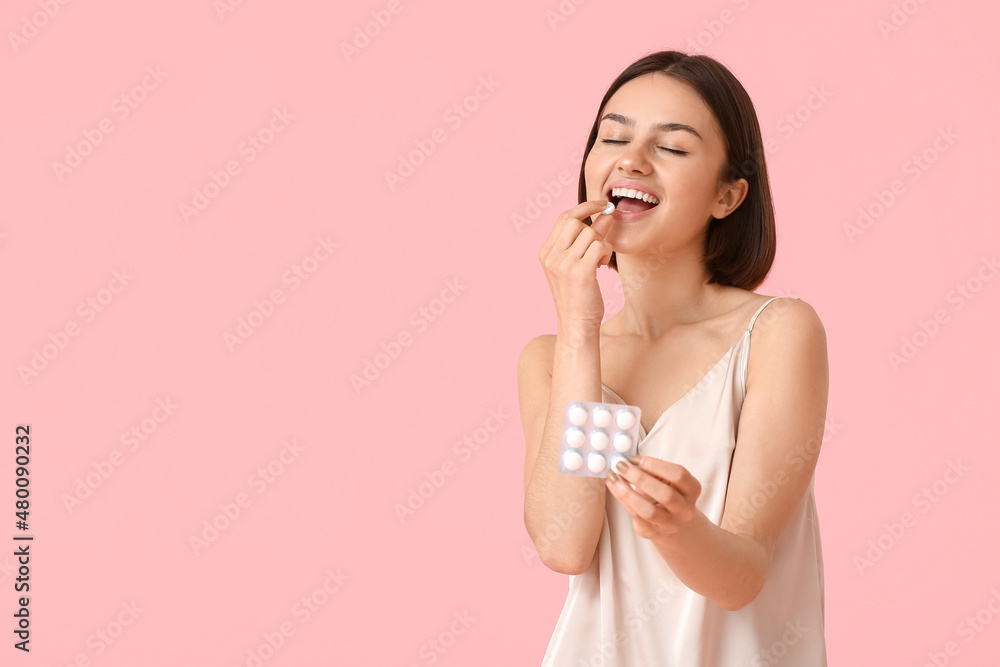 Young woman in pajamas and with chewing gum on color background Young woman in pajamas and with chewing gum on color background