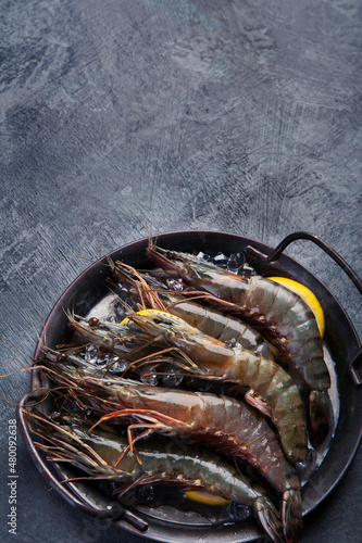Raw shrimps on dark background.