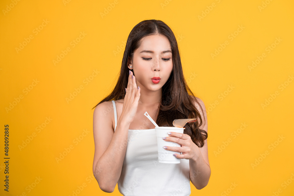 Beautiful Asian woman eating spicy instant noodles. She enjoys eating fast food. Beautiful Asian woman eating spicy instant noodles. She enjoys eating fast food.