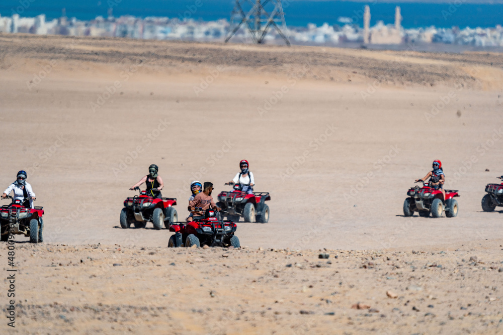 People driving quad bikes during safari trip in Arabian desert not far from Hurghada city, Egypt People driving quad bikes during safari trip in Arabian desert not far from Hurghada city, Egypt