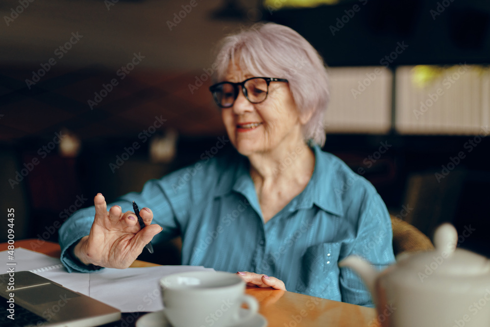 Happy senior woman working in front of laptop monitor sitting Lifestyle unaltered Happy senior woman working in front of laptop monitor sitting Lifestyle unaltered