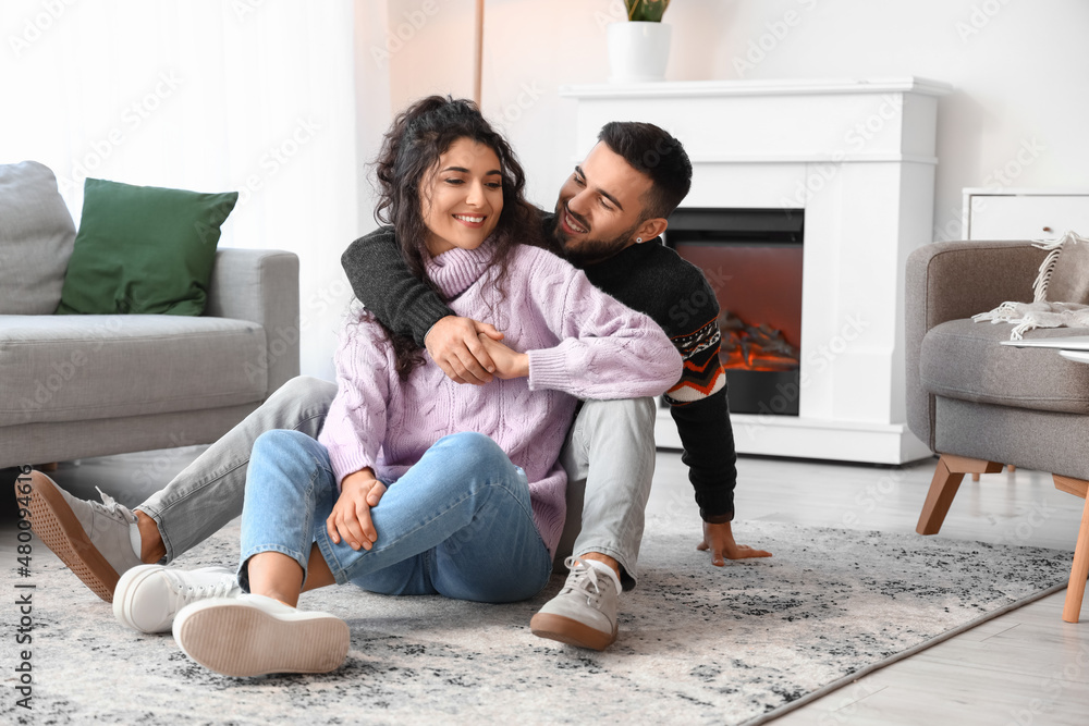 Happy young couple wearing warm sweaters at home Happy young couple wearing warm sweaters at home