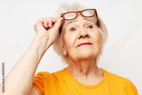 Portrait of an old friendly woman health lifestyle eyeglasses treatment light background