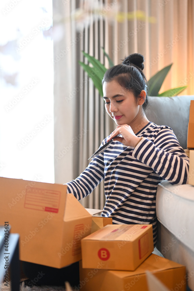 Young woman preparing parcel boxes for delivery to customer. Startup small business SME concept. Young woman preparing parcel boxes for delivery to customer. Startup small business SME concept.
