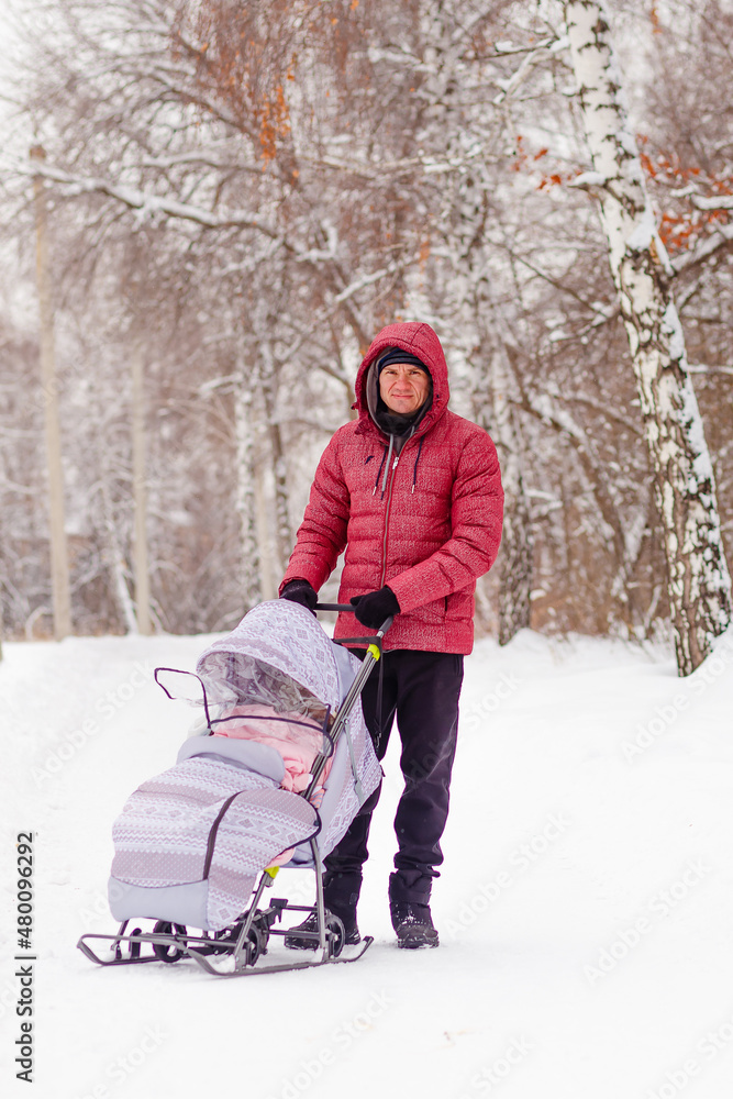 man walks with a child on a sled in winter man walks with a child on a sled in winter