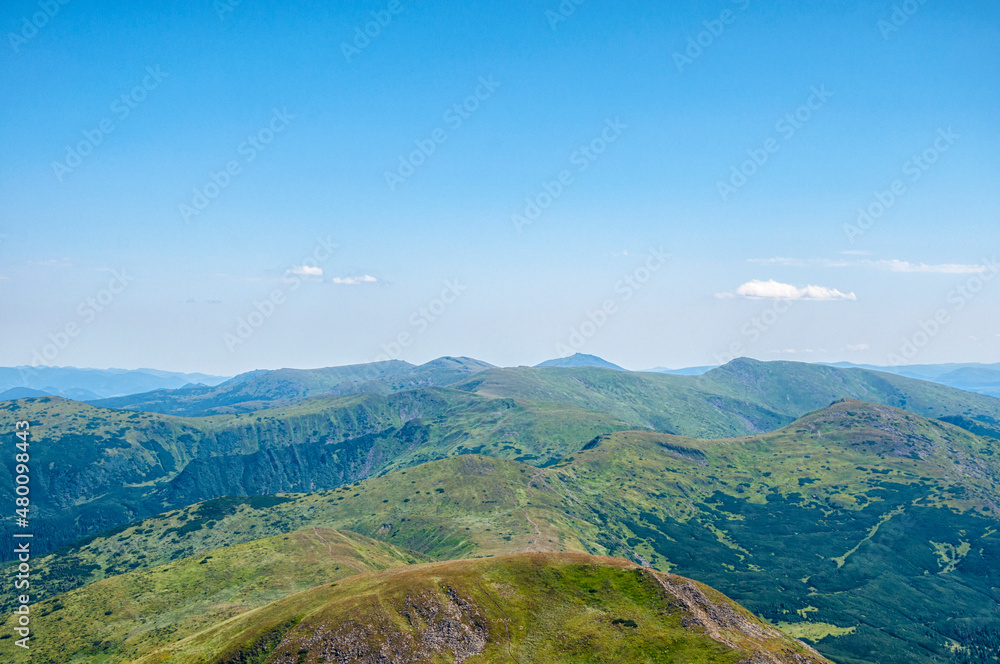 beautiful, summer slopes of mountains covered with green young grass against the blue sky, travel. High quality photo