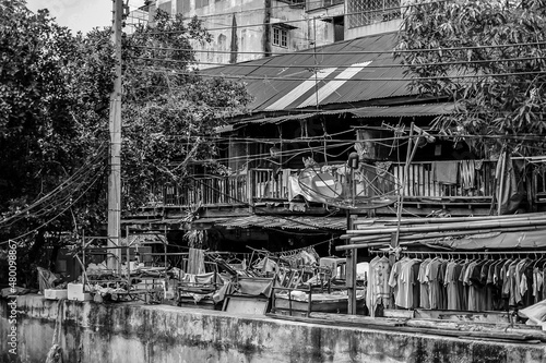 Black & White Asian, Thailand slum zone with rooftop, electric pole, tree, garbage, satellite in picture