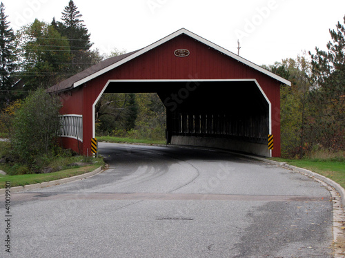 a red covered bridge on a travel road