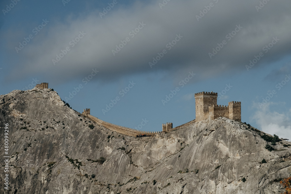 Crimea. Genoese fortress. Towers of the old fortress in the distance against the blue sky in sunny weather