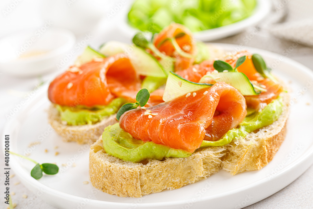 Open sandwiches with salted salmon, guacamole avocado and microgreens. Seafood. Healthy food. Open sandwiches with salted salmon, guacamole avocado and microgreens. Seafood. Healthy food.