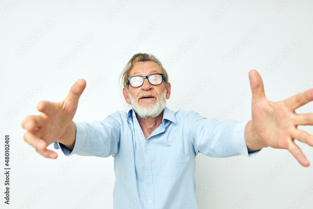 old man in blue shirts gestures with his hands isolated background old man in blue shirts gestures with his hands isolated background