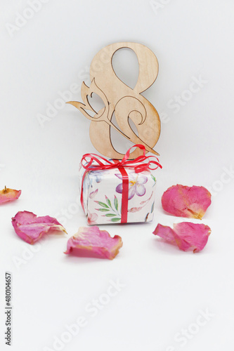 Greeting card with rose petals and a gift for March 8