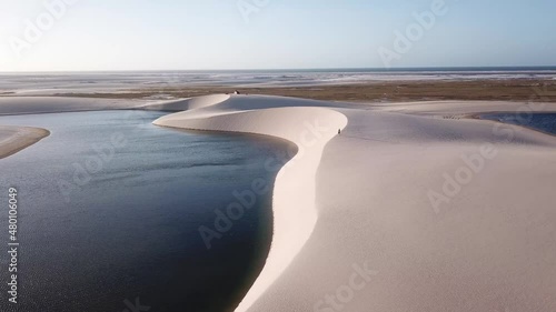 Lonely guy walking alone in the dunes of Lençóis Maranhenses National Park aerial view - One of the most beautiful places in Brazil photo