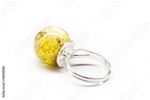 Yellow flower ring with resin. Cute piece of handmade jewelry. Natural dwarf everlast blooms collected in Poland. Selective focus on the details, blurred background.
