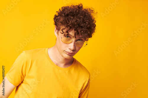 guy with red curly hair Youth style glasses studio casual wear yellow background unaltered