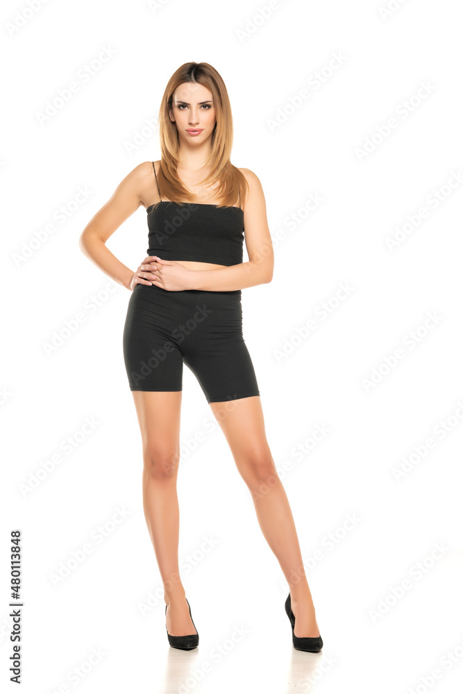 Fototapeta premium Young beautiful woman in cycling pants and high heels posing in studio