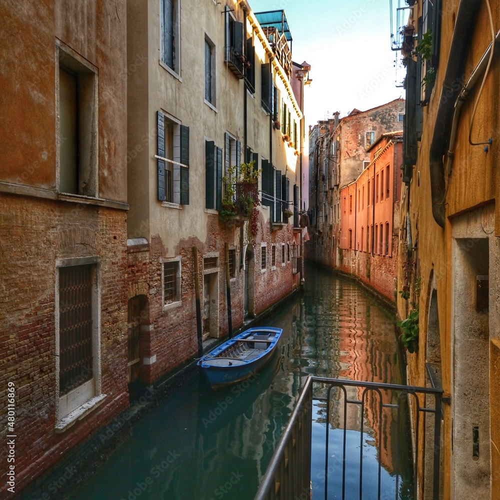 small venetian canal surrounded by characteristic and historic buildings 