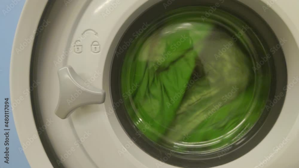 Green laundry in washer machine washing Green laundry in washer machine washing