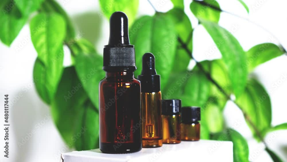 Different empty bottles of essential oils rotate 180 degrees on a white background with green leaves. High quality 4k footage Different empty bottles of essential oils rotate 180 degrees on a white background with green leaves. High quality 4k footage