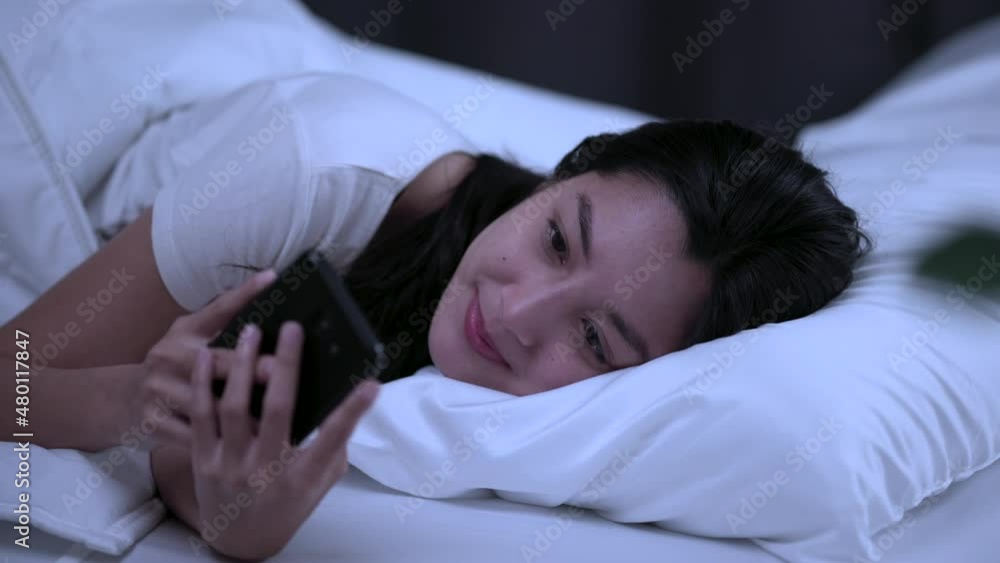 Pretty asian woman using smart phone on bed to social media at home. Lifestyle of young beautiful female using mobile phone to network internet online before sleep. Pretty asian woman using smart phone on bed to social media at home. Lifestyle of young beautiful female using mobile phone to network internet online before sleep.