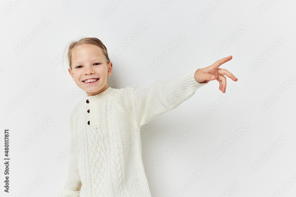 cheerful little girl in a white sweater hand gesture cheerful little girl in a white sweater hand gesture