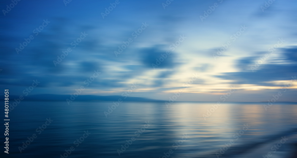 Blurred blue sea background at sunset, abstract natural background