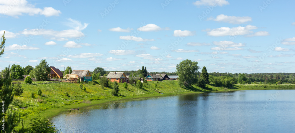 Typical Russian landscape. Russian village on the shore of the lake. Panoramic photo