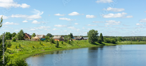 Typical Russian landscape. Russian village on the shore of the lake. Panoramic photo