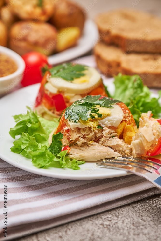 Portion of delicious chicken aspic on a plate isolated on concrete table Portion of delicious chicken aspic on a plate isolated on concrete table