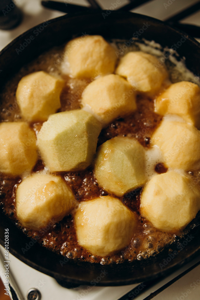 peeled apples are caramelized in a fry pan with butter. caramelizing apples for making tart tatin. peeled apples are caramelized in a fry pan with butter. caramelizing apples for making tart tatin.