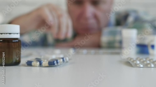 Suffering Person Taking Medicines. Man with a Serious Sickness Takes Home Treatment. Pills and Drugs, Addiction and Abuse Concept.