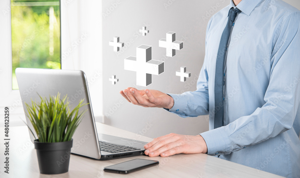 Businessman hold 3D plus icon, man hold in hand offer positive thing such as profit, benefits, development, CSR represented by plus sign.The hand shows the plus sign Businessman hold 3D plus icon, man hold in hand offer positive thing such as profit, benefits, development, CSR represented by plus sign.The hand shows the plus sign