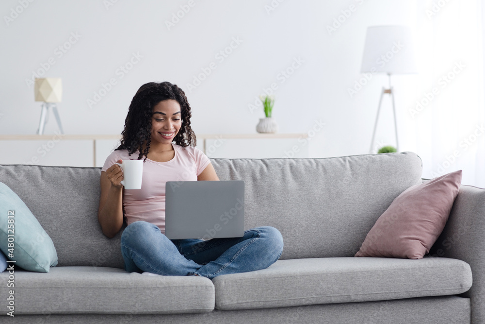 Businesswoman working on computer sit at home, hold coffee cup in hand, managing business, freelancing Businesswoman working on computer sit at home, hold coffee cup in hand, managing business, freelancing