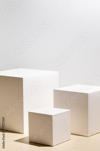 Abstract minimal scene - empty stage with three white rectangle podiums on beige background. Pedestal for cosmetic product and packaging mockups display presentation © Aleksandra Konoplya