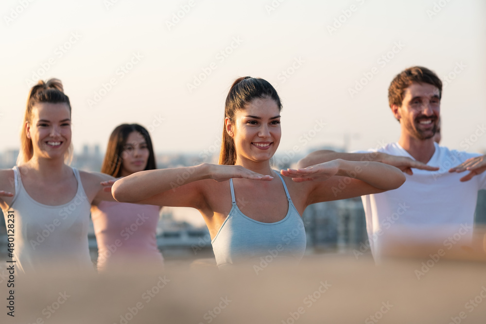 Naklejka premium Group of happy fit friends exercising together outdoors. Sport people healthy lifestyle concept