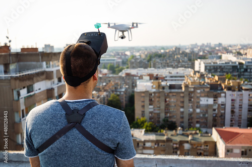 Fotografia Young technician man flying UAV drone with remote control in city