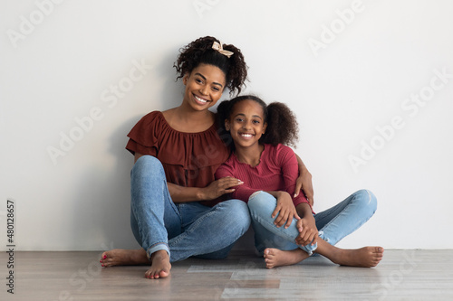 Loving black family posing on floor at home